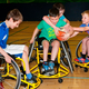 Kids playing wheelchair basketball.